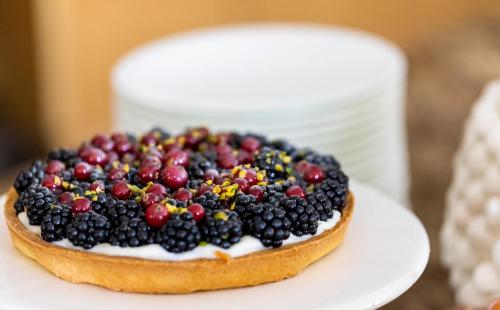 a cake with berries on top on a white plate at Donna Carmela Resort & Lodges in Riposto