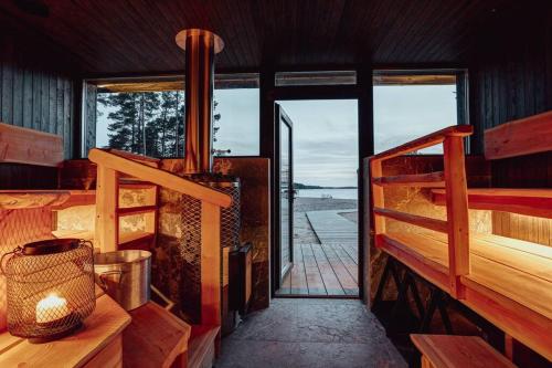 a room with a balcony with a view of the ocean at Saunamäki Resort - Beachfront in Salo