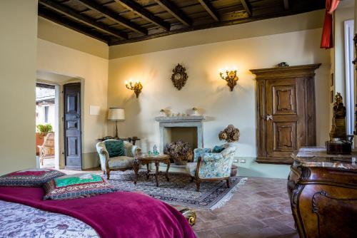 a bedroom with a bed and chairs and a fireplace at B&B Locanda Tempi Lontani Adults Only in Orta San Giulio