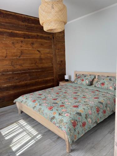 a bedroom with a bed with a wooden wall at Liepu Apartment in Ventspils