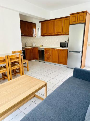 a kitchen with wooden cabinets and a refrigerator at Cost Mari Almyrida New by ZAGO Boutiqe hotels in Almirida