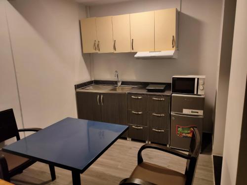 een kleine keuken met een tafel, een wastafel en een magnetron bij NEW DREAM PLAZA HOTEL APARTMENT L.L.C in Dubai