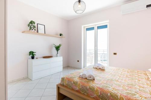 una camera da letto bianca con un letto e una finestra di Dimora dei Naviganti - 15 Min dalla Costiera Amalfitana Vista Mare con Jacuzzi a Salerno