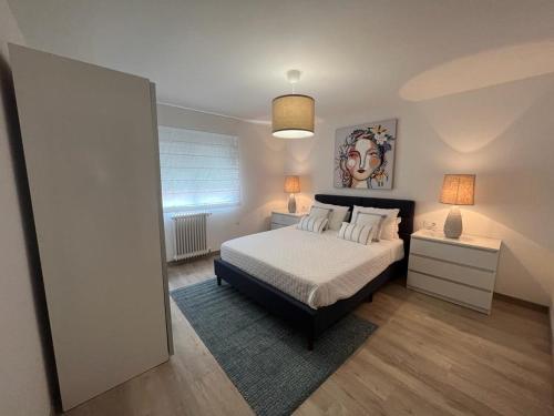 1 dormitorio con 1 cama con sábanas y almohadas blancas en Tu Piso en Portonovo en Portonovo