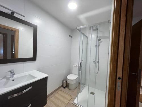 a bathroom with a glass shower and a sink at Tu Piso en Portonovo in Portonovo