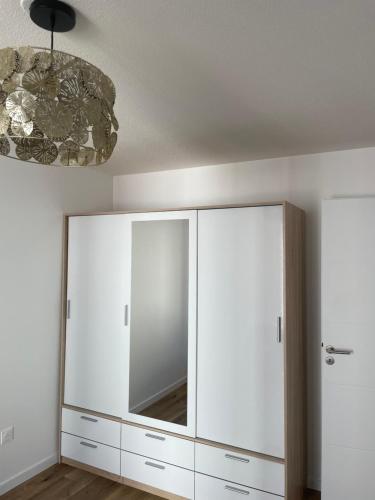 einen großen weißen Schrank in einem Zimmer mit Spiegel in der Unterkunft Marcopolo Luxury Appartement in Bischheim