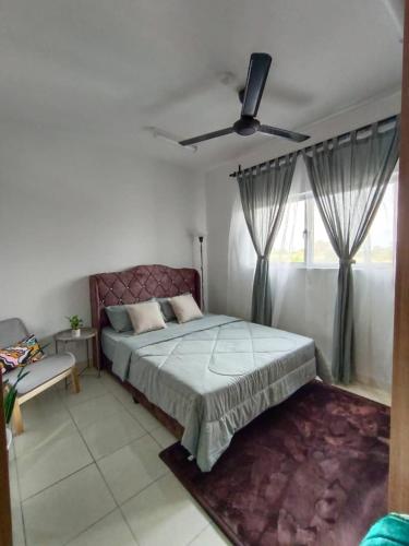 a bedroom with a bed and a ceiling fan at Qilayna guest room in Sepang