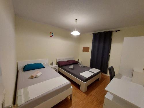 Habitación pequeña con 2 camas y mesa. en Apartment Adriatic, Cres en Cres