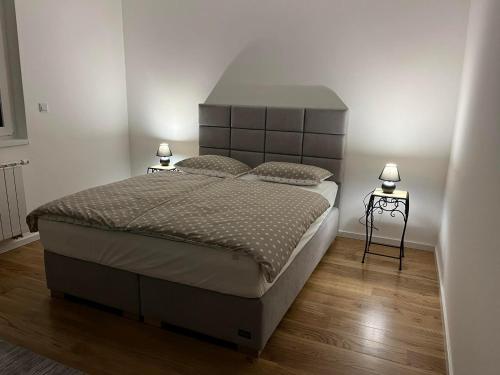 - une chambre avec un grand lit et deux lampes dans l'établissement Apartmani Behđetović, à Tuzla
