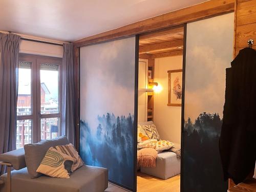 a room with a sliding glass door with a bedroom at Il Focolare - Attico centrale di charme in Sauze dʼOulx