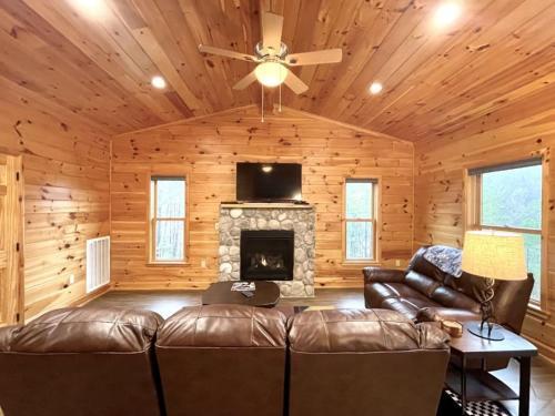 un soggiorno con divano e camino di Perfect Stay for Fishing, Hiking, R&R - Charming Sapphire Bear Home a Tellico Plains