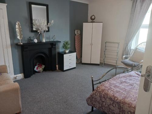 a living room with a bed and a fireplace at Llandudno Beachfront 2 Double Bedroom Apartment 2nd Floor in Llandudno
