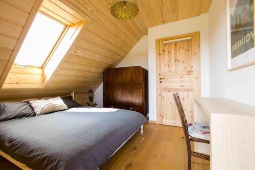 a bedroom with a bed and a window in a attic at Chata Buena Vista in Wawrzka