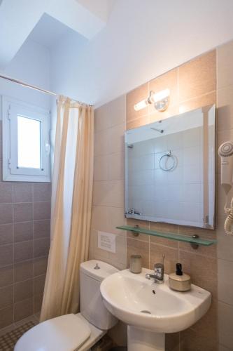 a bathroom with a sink and a toilet and a mirror at Annis House in Skiathos