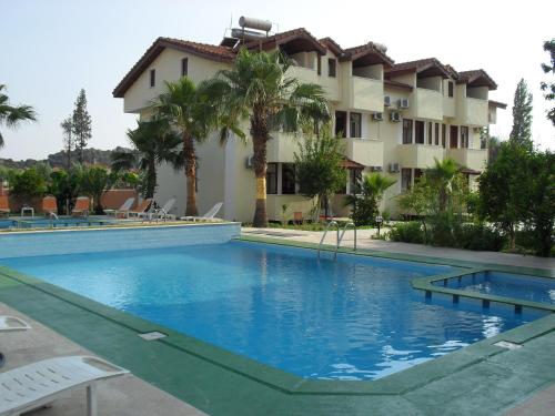 a large swimming pool in front of a building at Villa Ozalp Apartments in Dalyan