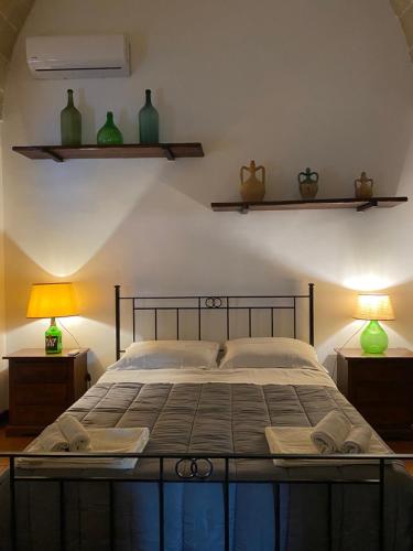 1 dormitorio con 1 cama con 2 lámparas y estanterías en Palazzo Giordano Luxury Rooms, en Squinzano