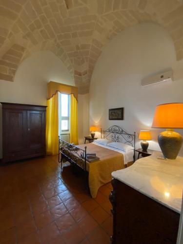 ein großes Schlafzimmer mit einem Bett und einem Fenster in der Unterkunft Palazzo Giordano Luxury Rooms in Squinzano