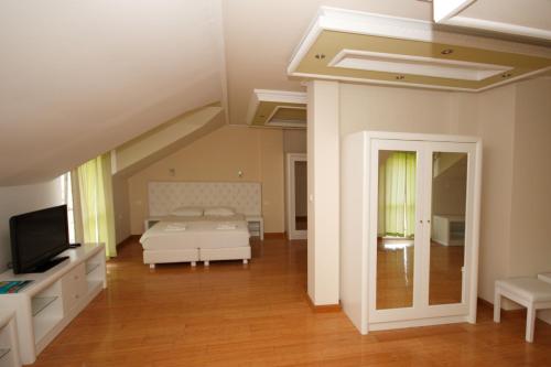 1 dormitorio con 1 cama y TV en una habitación en Hotel RR, en Herceg-Novi