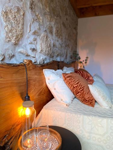 a bed with a table with a lamp and pillows at Emily's House in Castro Daire
