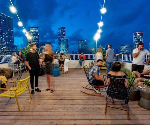 a group of people sitting on a deck at night at Domus Metro Hotel in Tel Aviv