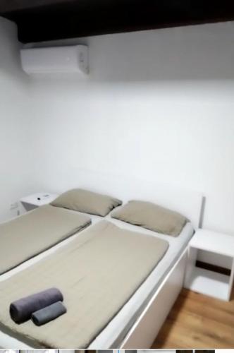 Bett in einem Zimmer mit einer weißen Wand in der Unterkunft Lenilenii Bungalow in Jajce