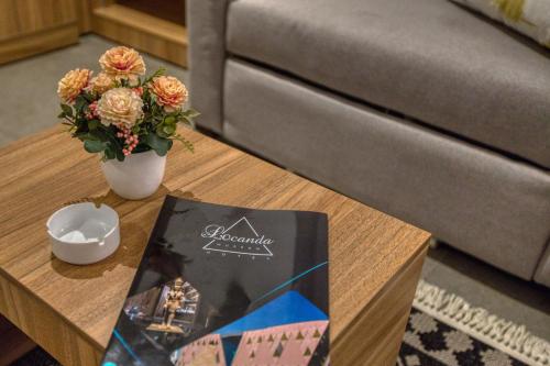 a coffee table with a book and a vase of flowers at Locanda Museum Hotel in Giza