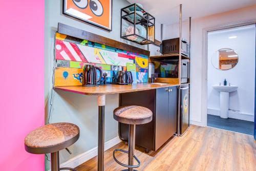 a kitchen with a bar and stools in a room at Pass the Keys Cosy Studio flat near hospital in Westcliff-On-Sea