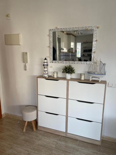 a dresser in a room with a mirror at Sea-view 3-bedroom apartment near Alicante in Arenales del Sol