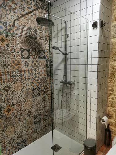 a bathroom with a shower with a tile wall at Casiñas A Granxa in Vimianzo