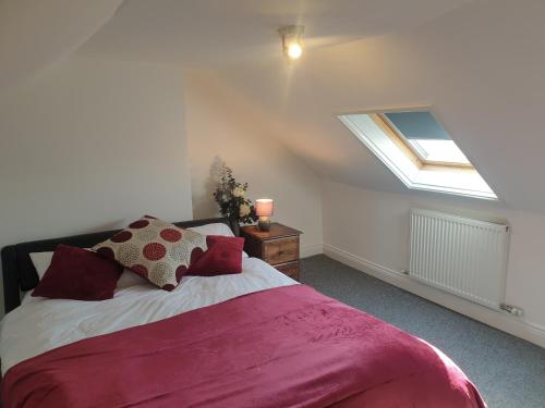 una camera con un grande letto e un lucernario di Quaint cottage near to town, beach and station a Exmouth