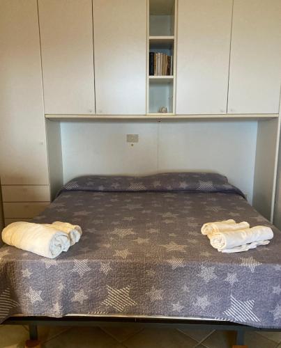a bed in a room with two towels on it at Ginevra SurfHouse in Palau