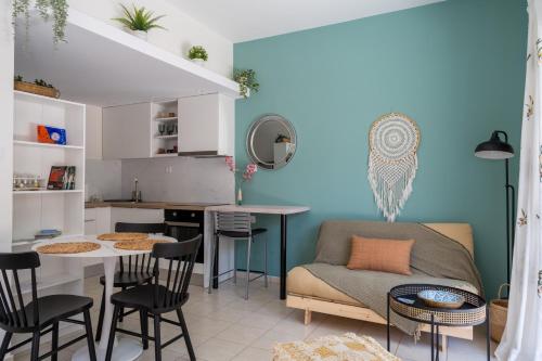 eine Küche und ein Wohnzimmer mit einem Sofa und einem Tisch in der Unterkunft The Garden of Zephyrus - Halepa in Chania