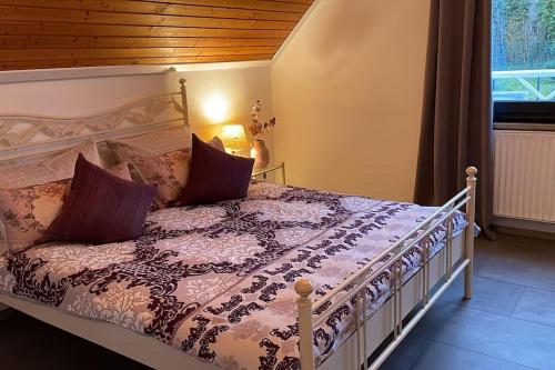 a bedroom with a bed with a purple comforter at Ferienhaus Greta in Mastershausen