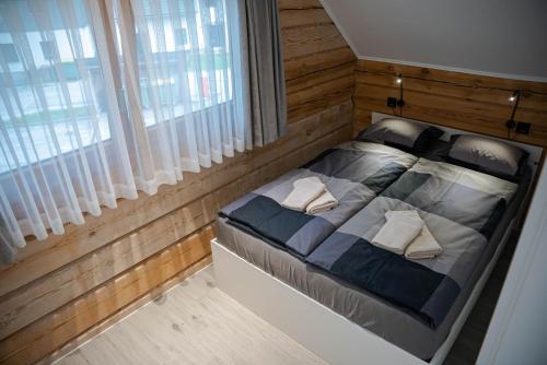 Schlafzimmer mit einem großen Bett und Holzwänden in der Unterkunft ALPEART HOLIDAY units in Bohinj