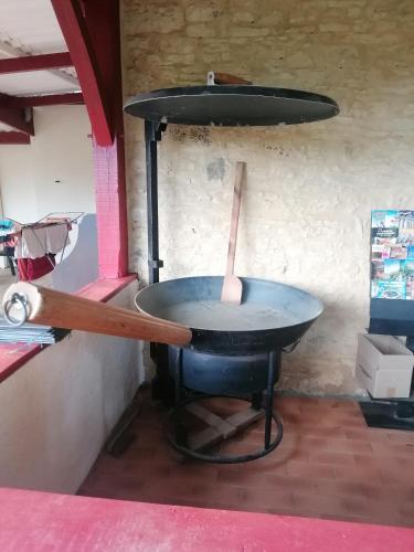un barbecue avec un bâton en bois dedans dans l'établissement L escale de larcher, à Saint-Aubin-de-Nabirat