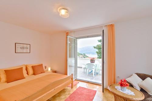 1 dormitorio con 1 cama y balcón con mesa en Apartments Sarah, en Korčula