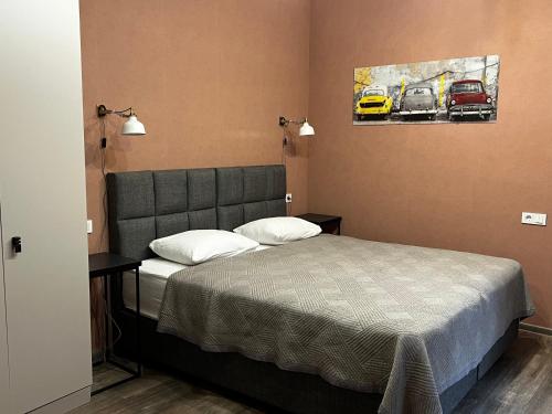 a bedroom with a bed and a painting of cars at Chikhi in Tbilisi City
