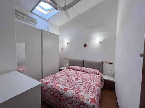 ein kleines Schlafzimmer mit einem Bett mit einer roten Tagesdecke in der Unterkunft La Babbaiola di Torre delle Stelle in Torre delle Stelle
