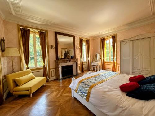 - une chambre avec un lit, une chaise et une cheminée dans l'établissement Château de Moliens, à Moliens