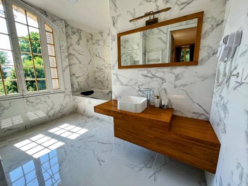 y baño con lavabo y espejo. en Château de Moliens, en Moliens