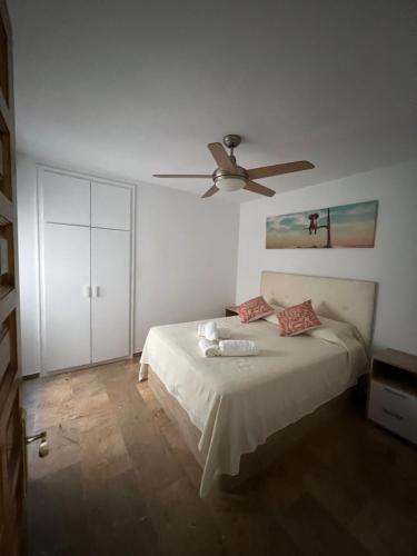 Un dormitorio con una cama con ventilador de techo. en exclusiva primera línea de playa, en Aguadulce