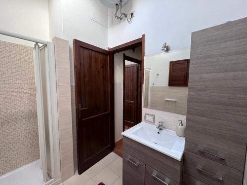 ein Bad mit einem Waschbecken und einem Spiegel in der Unterkunft La Babbaiola di Torre delle Stelle in Torre delle Stelle