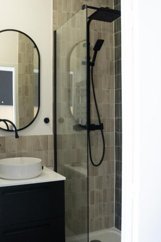 une salle de bain avec une douche avec un lavabo et un miroir dans l'établissement Appartement 2 pièces Montpellier centre, à Montpellier