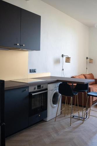 une cuisine avec un lave-linge, une table et des chaises dans l'établissement Appartement 2 pièces Montpellier centre, à Montpellier