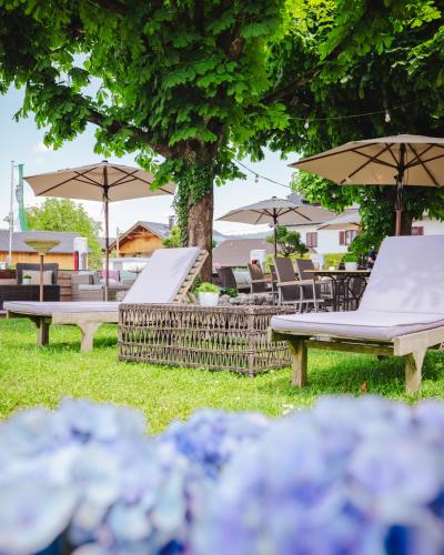 a group of chairs and umbrellas in a park at Hotel Kaiserhof in Anif