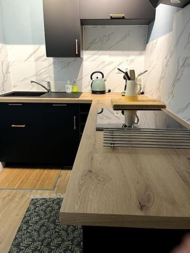 une cuisine avec un comptoir en bois et un évier dans l'établissement # Charme, Calme & Cosy # Brive #, à Brive-la-Gaillarde