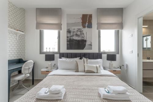 a bedroom with a large bed with two towels on it at Holysuite Savyon View Tower in Jerusalem