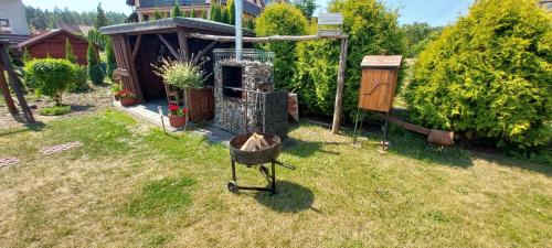 a grill in a yard next to a house at Domek Tomek in Wilkasy