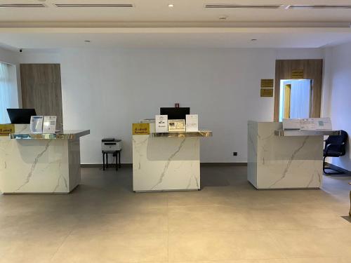 una habitación con paredes blancas y mesas con cajas. en فندق رؤيا الاندلس النخبة - Roaya Alandalus Elite Hotel, en Medina