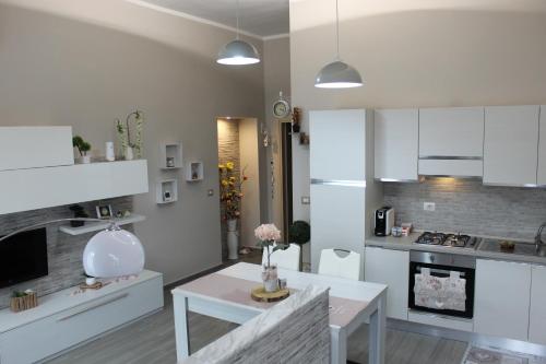 a kitchen with white cabinets and a table in a room at CAMARDA SUITE in Bernalda